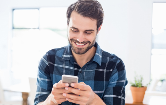 man looking at mobile phone while smiling