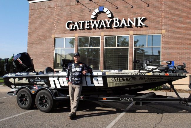 Bob Downey posing with his boat outside of Gateway Bank