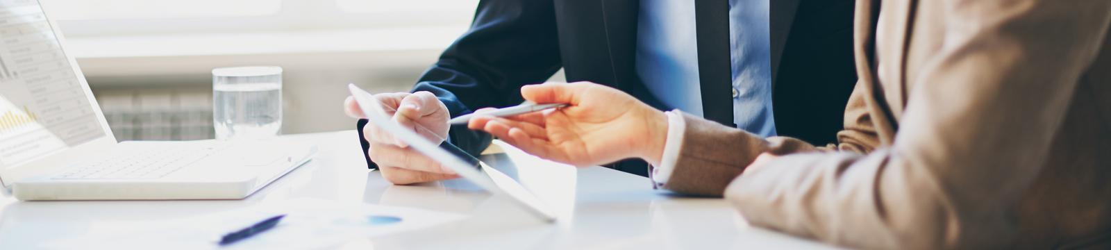 two office workers looking at a white tablet