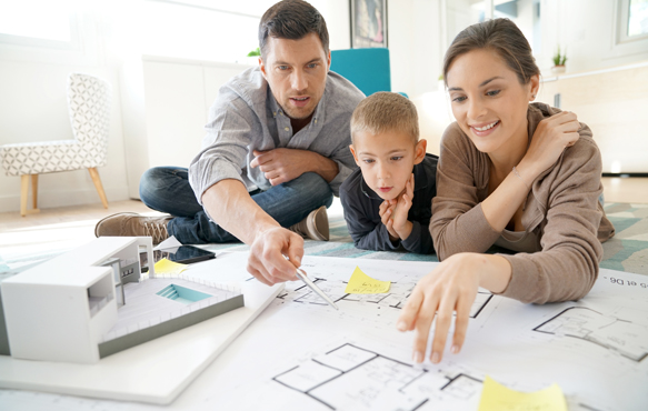 Mother, father, and small child looking over home renovation blueprints.