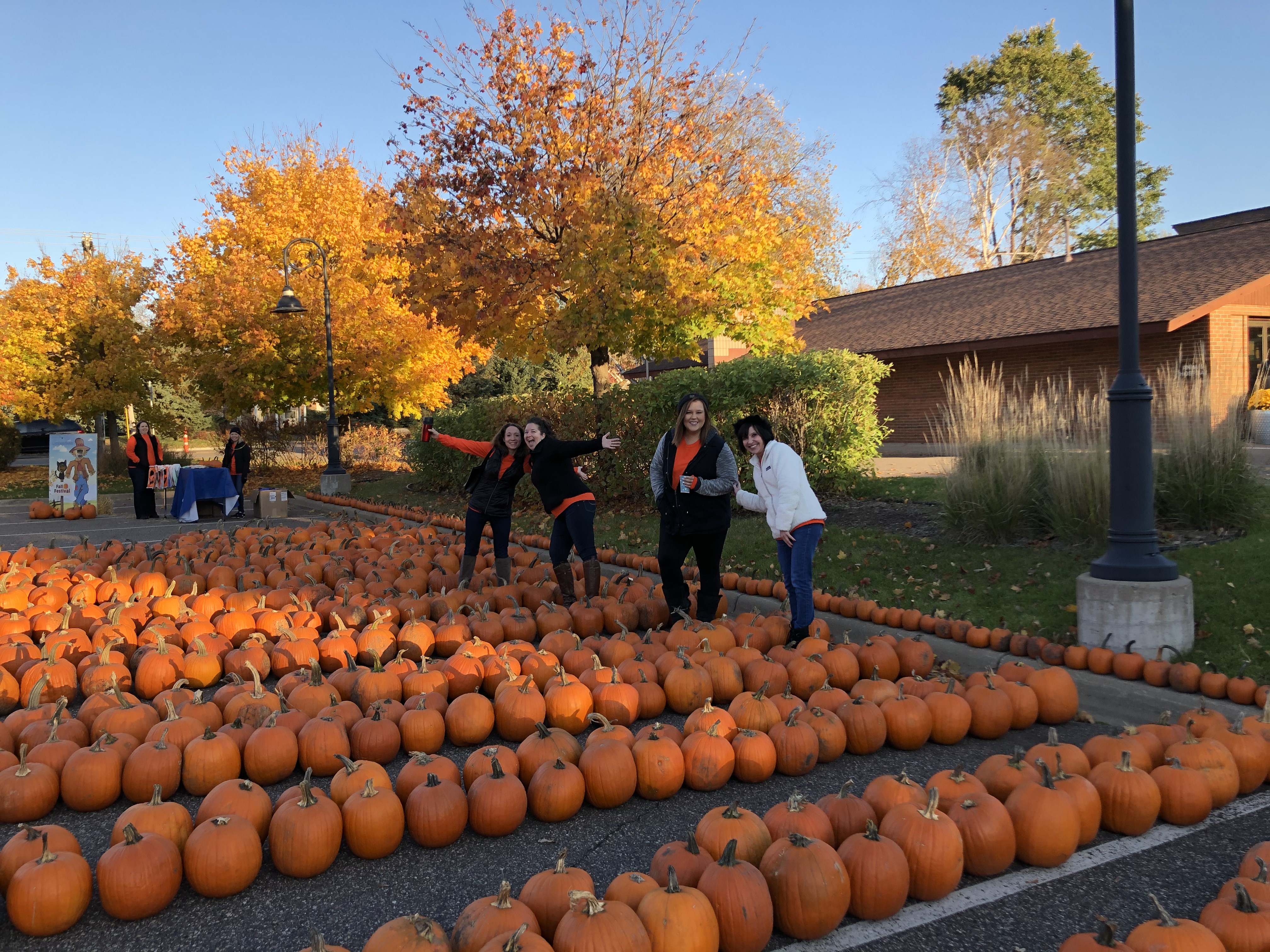 Gateway Bank associates standing around pumpkins at the fall festival laughing.