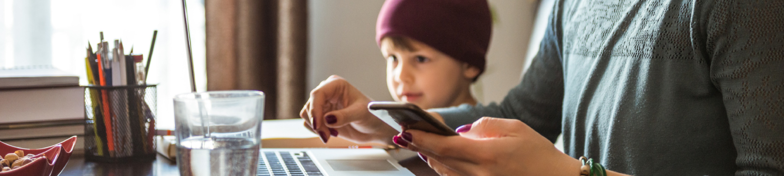 mother using a mobile device at a desk