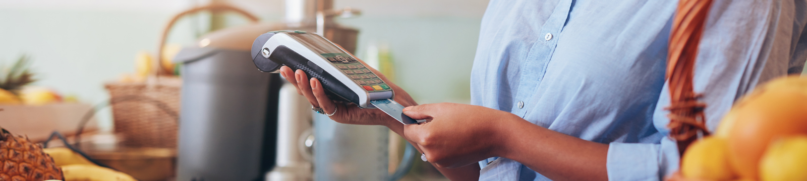 Woman processing a credit card in a credit card machine at a store